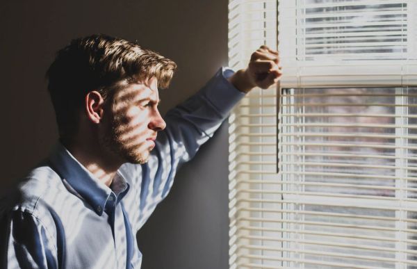 homme devant des stores à enrouleur